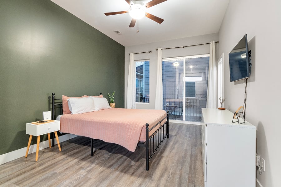A spacious, calming bedroom with a comfy queen sized bed, end suite bathroom and patio accessideal for unwinding and feeling at home during a longer stay