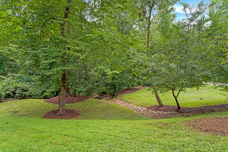 Tranquil view of front yard, with a stream running through the property.