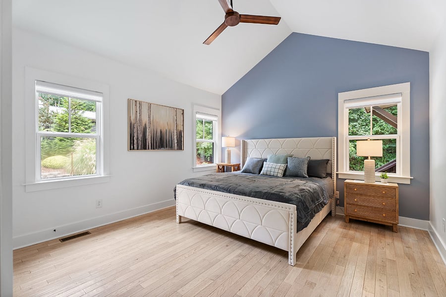 King bed in Primary bedroom with high vaulted ceilings plenty of natural light.