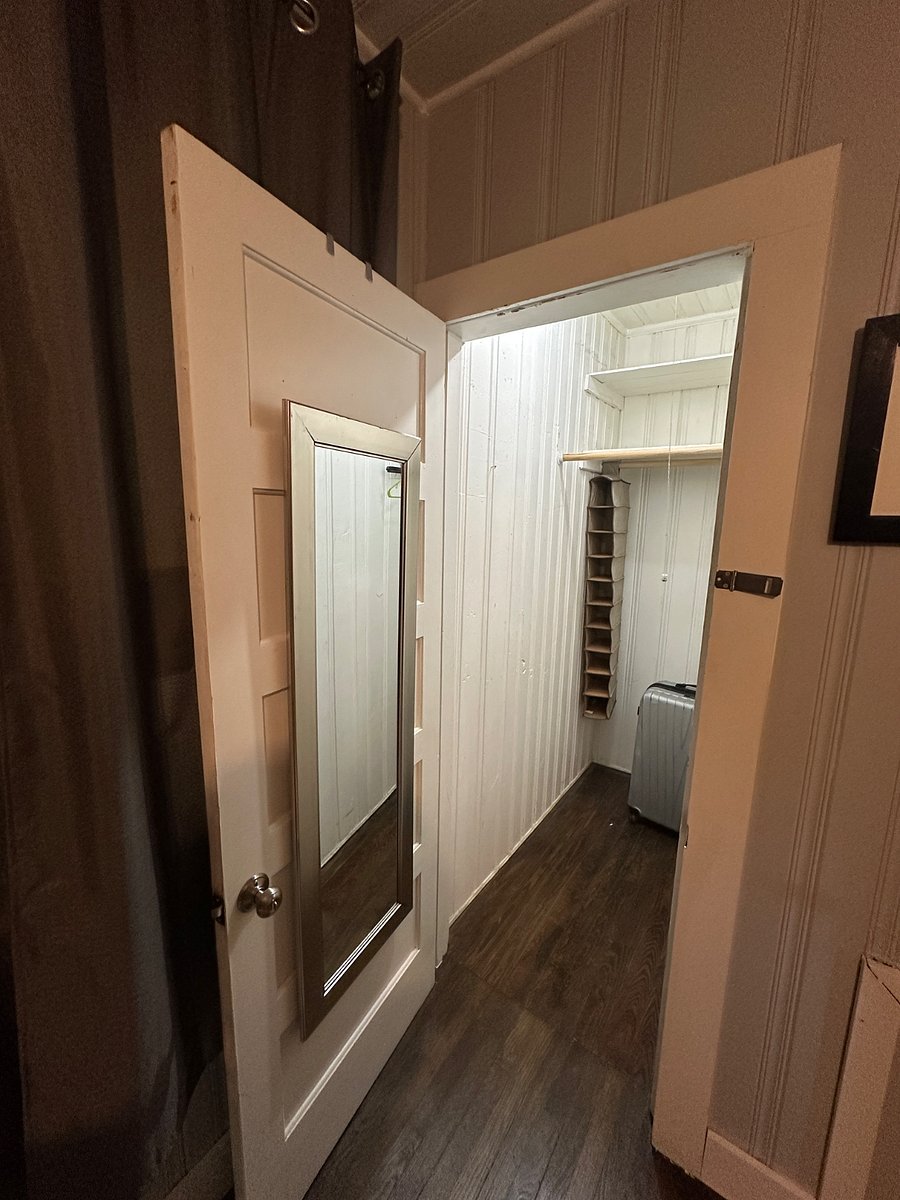 Large closet with multiple poles for hanging clothes. 