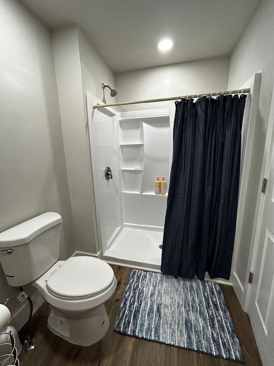 Toilet and shower in bathroom. 