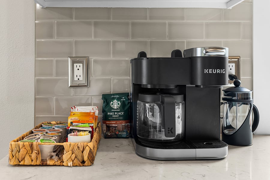 Coffee/tea station includes drip, pod, and French press options, and electric tea pot with a starter assortment of regular, decaf, herbal, hot cocoa, and apple cider. Sugar and half and half.