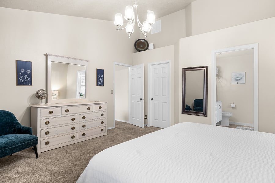 Main floor Master Suite with luxury Saatva king bed, dresser, walk in closet, hamper, and hangers, and blackout curtains. Golf course view.