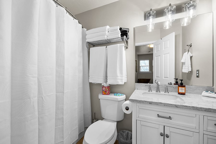 Upstairs full shower/tub bathroom with starter supplies. Shampoo/Conditioner, hand and body soaps, make-up wipes, flushable wipes, q-tips, and flossers.