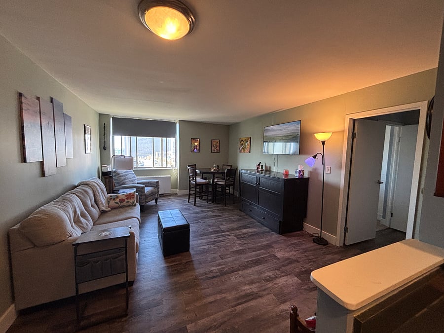 Living room with queen size murphy bed under Smart TV. Views of Kansas City and lots of natural light