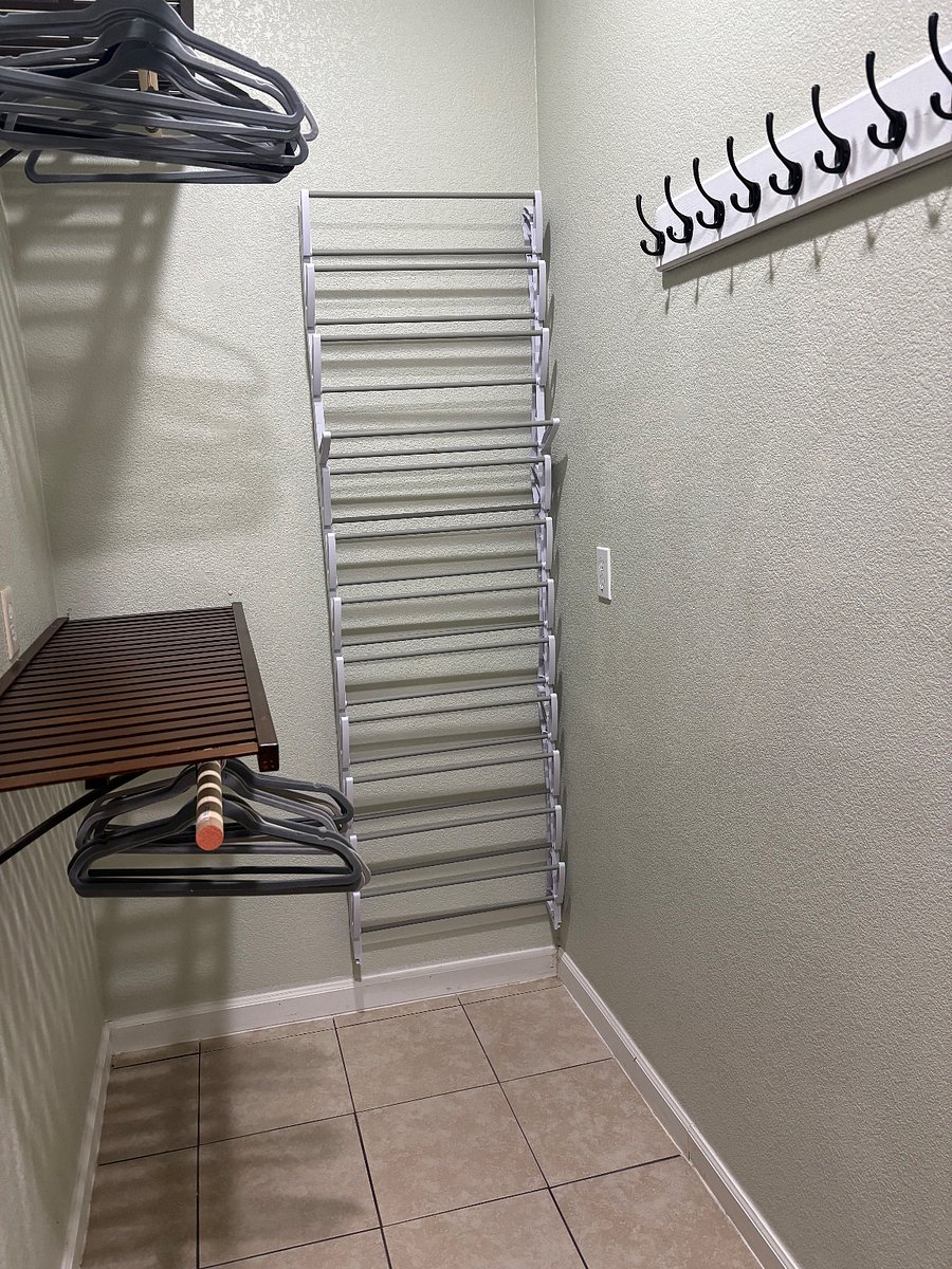 Walk-in closet with shoe rack, double hanging bars, and coat hooks.