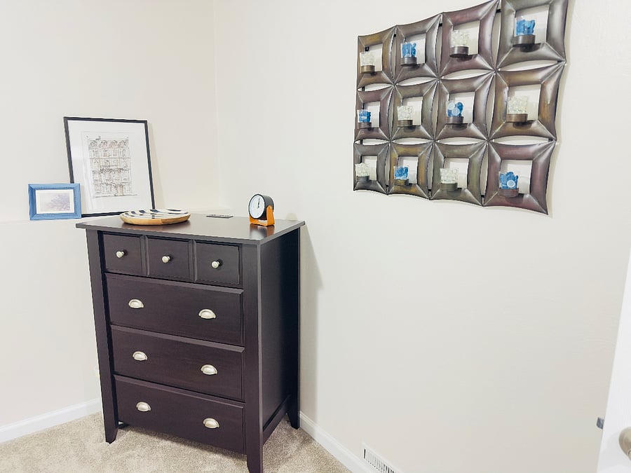 Bedroom dresser with multiple drawers for storage and a built-in charging station on top, perfect for phones and devices. Clean, functional setup with tasteful decor for a comfortable and convenient stay.