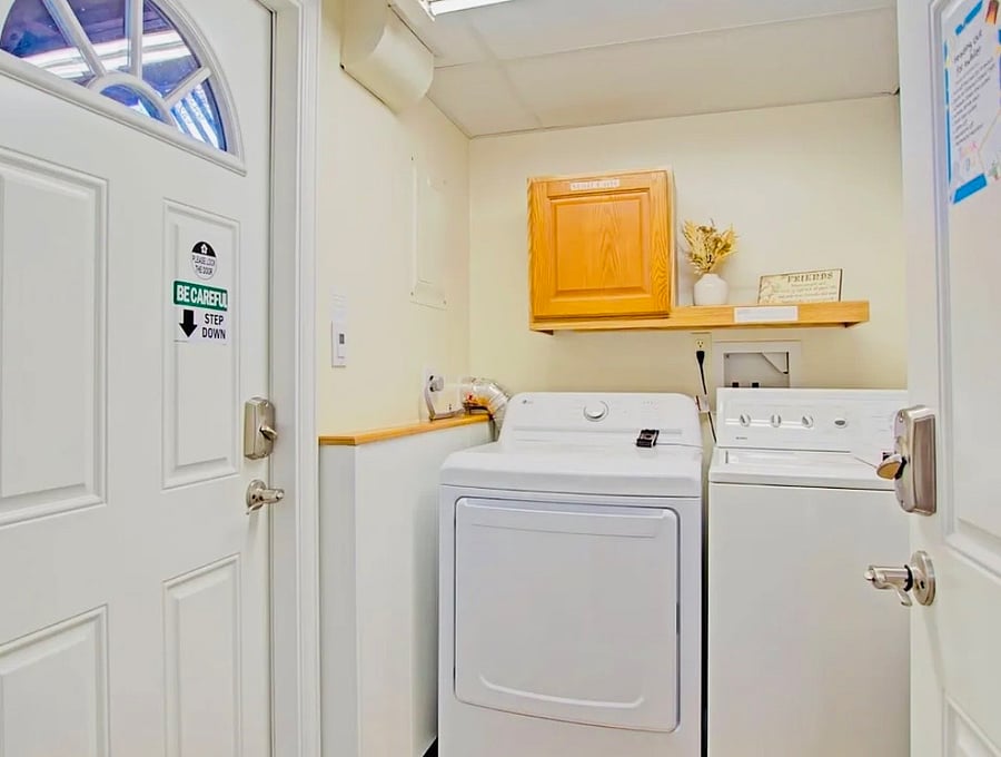 Convenient laundry area with washer and dryer, stocked with complimentary detergent and essential supplies. Clean, easy-to-use setup designed to make longer stays and everyday laundry simple and stress-free.