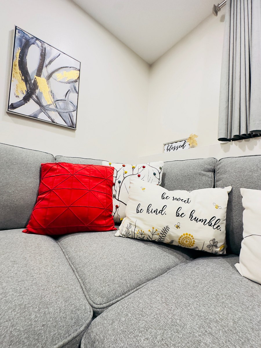 Cozy seating area with a comfortable sectional sofa, soft accent pillows, and warm, inviting decor. A perfect spot to relax, unwind, or enjoy a quiet moment indoors.
