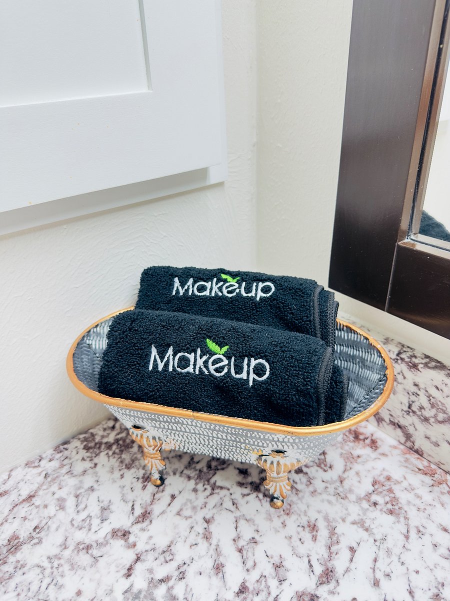 Soft black makeup towels are neatly folded and placed on the restroom counter for guest convenience. Thoughtfully displayed to help remove makeup while protecting white towels, they add a clean, stylish, hotel-like touch to the space.