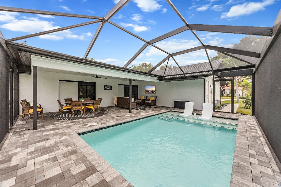 Make the most of your time outdoors with a spacious screened-in lanai featuring a private pool, dining area, lounge seating, and outdoor TV for ultimate relaxation.