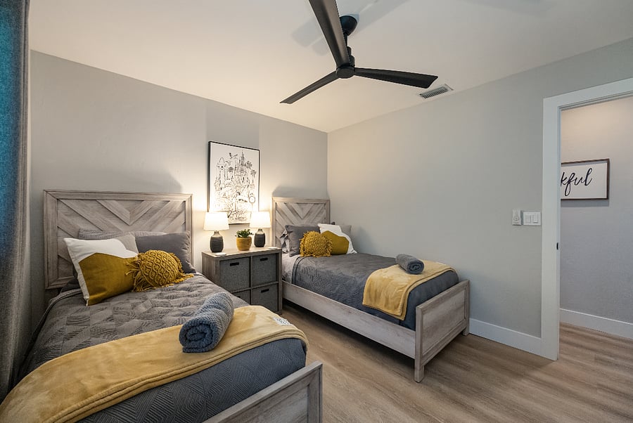 Side view with plenty of floor space for bags or play, warm bedside lamps, and an easy path to the hall.