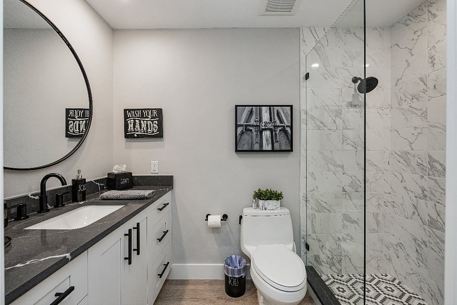 Full bathroom with a glass walk-in shower and decorative tile floor. Clean, simple, and stocked with the basics.