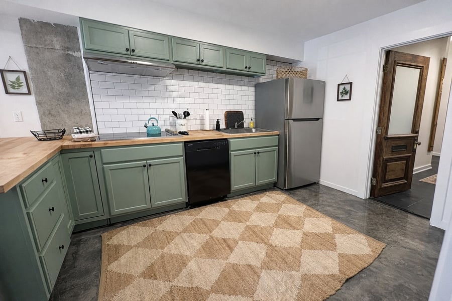 This kitchen has everything you need- electric cooktop, dishwasher, full fridge, airfryer/toaster oven, blender, bar area for prepping food, vent exhaust, fire extinguisher, plates, bowls, pots, pans, Tupperware, silverware, wine glasses, and kettle. 
