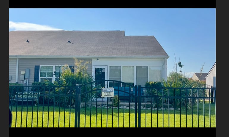 Backyard view of house, fencing, seating & patio