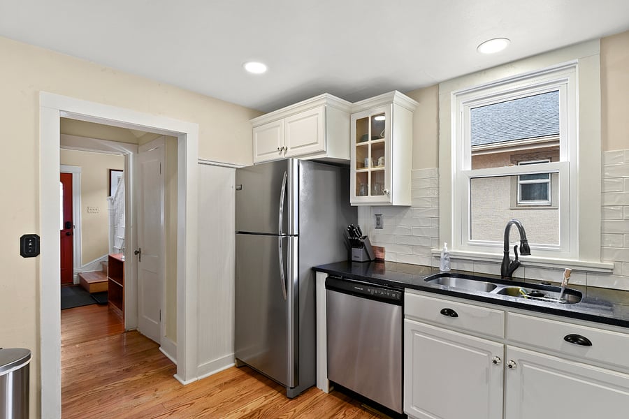 Kitchen with a dishwasher, lots of cabinets, and adjacent to the half bathroom. 