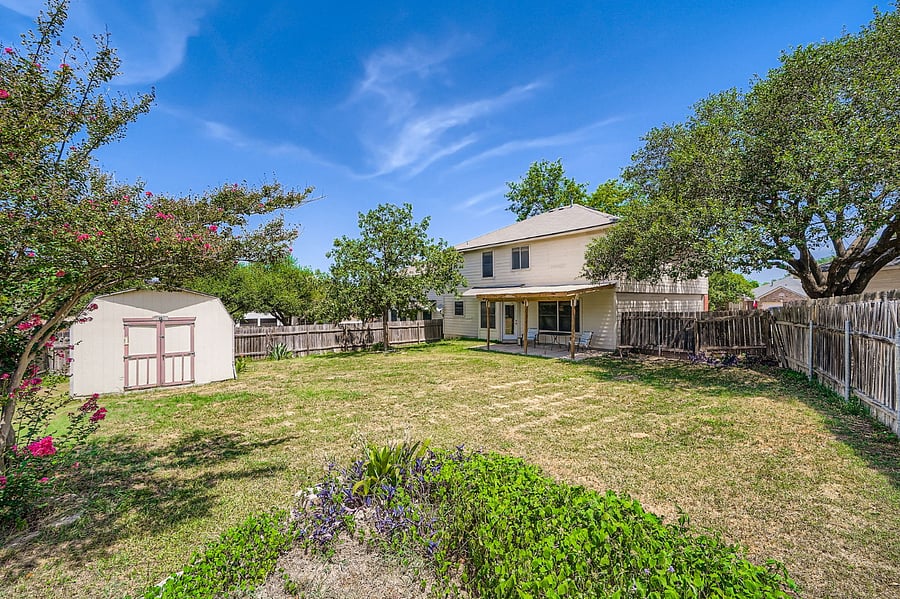 Private fenced backyard with covered patio for outdoor relaxation and kids playground