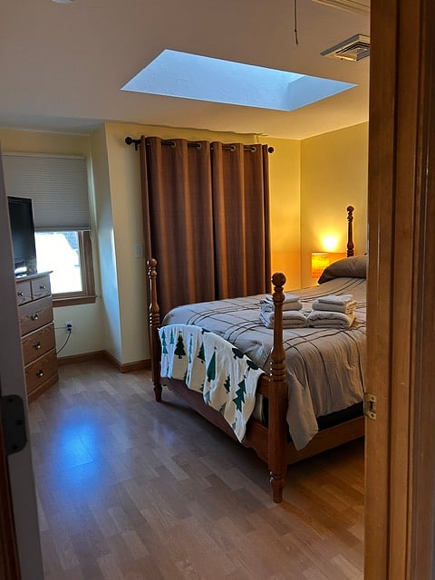 Bedroom with large closet behind drapes. 