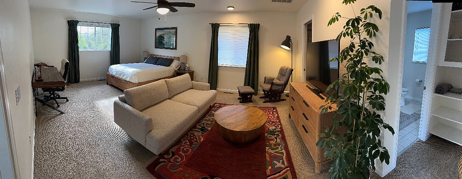 Spacious, comfortable living-and-sleeping area with clean furnishings and room to breathe.Queen bed, dresser, cozy seating, smart TV, and workspace  everything you need for a restful stay.