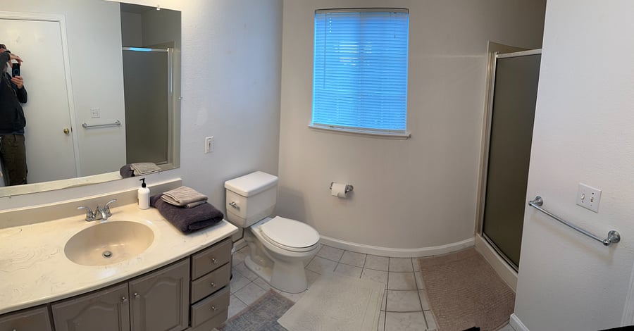 Clean, private bathroom with full shower, storage, and bright lighting.