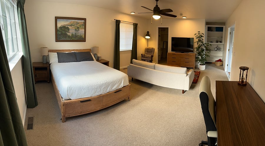 Queen bed, dresser, cozy seating, smart TV, and workspace  everything you need for a restful stay.