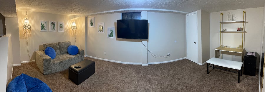 basement livingroom with desk work space full bathroom and some workout equiptment