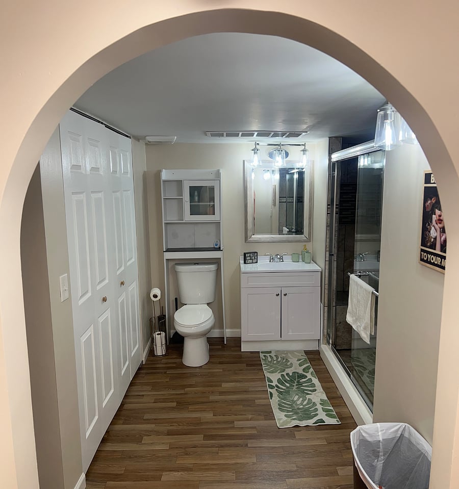 basement full bath walk in shower with six shower heads and rain down showers laundry unit in bathroom with walk in closent and extra storage under storage