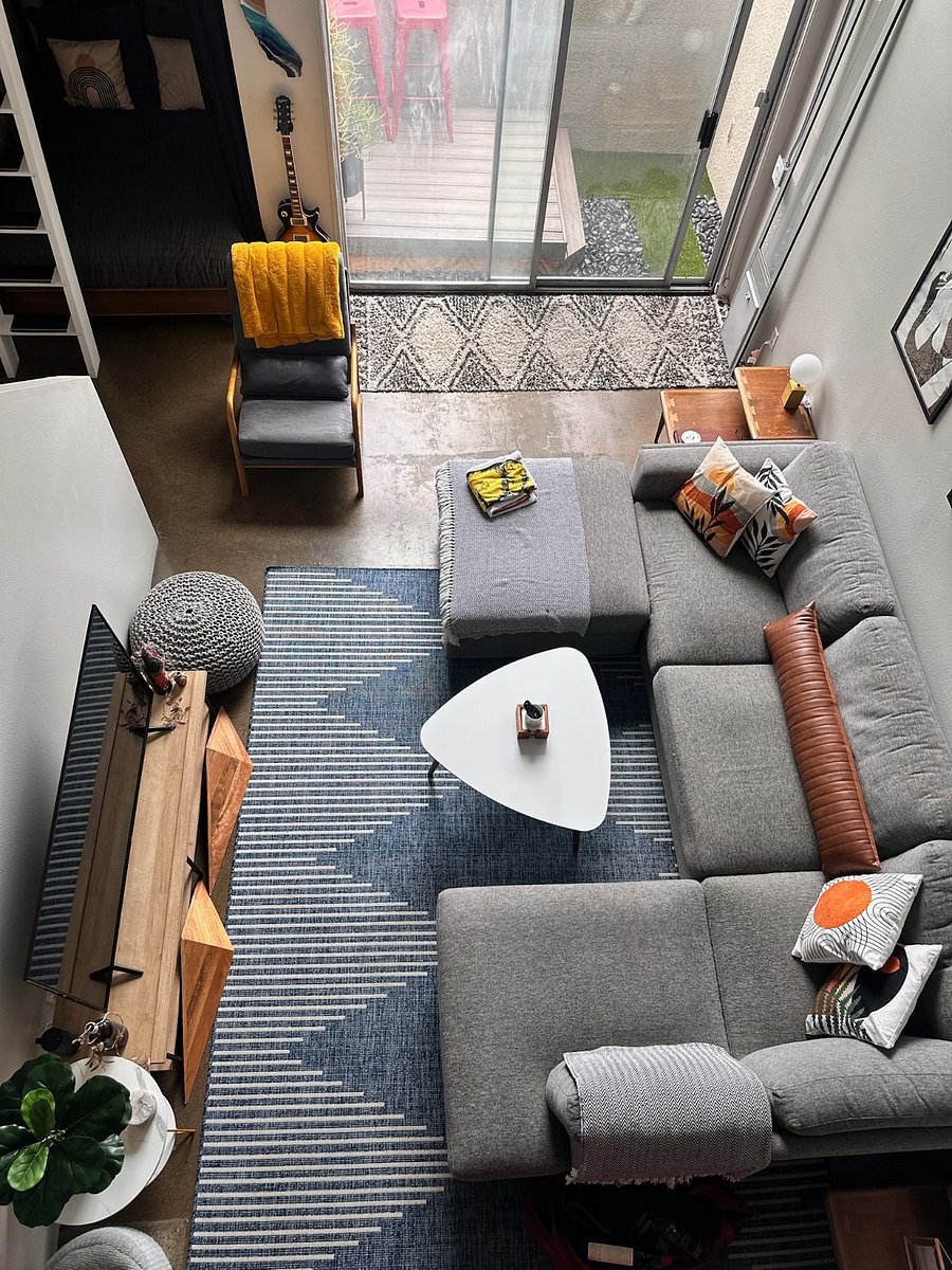 Large living room space with oversized u shaped couch and super tall loft ceilings