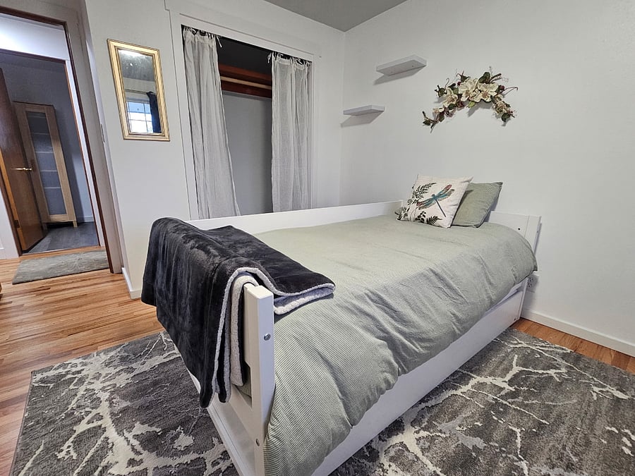 Unit B - Bedroom with twin daybed with trundle. Blackout curtains. TV, closet and dresser.
