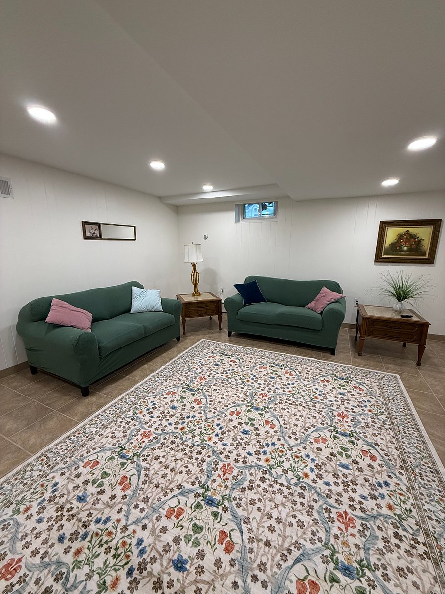 Another angle of the bright living room showing ample seating and open layout.