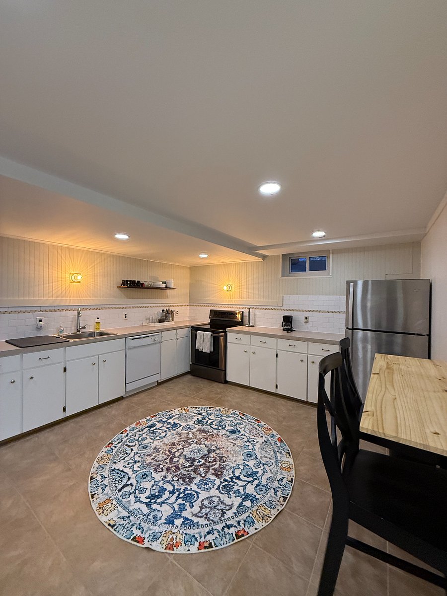 Well-equipped kitchen with full-size fridge, stove, microwave, and coffee setup.