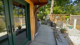 The boardwalk is bordered by a beachy landscape feature that ends in a corner shared sunken patio with a water feature. 