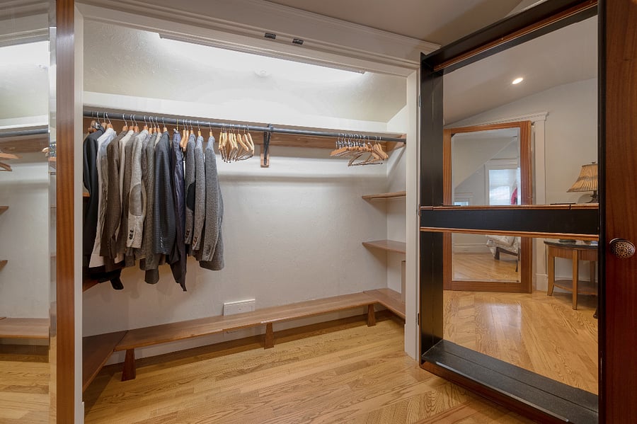 Large shelves on either end of inner closet provides additional storage space. Shelving for shoes lines the lower part of the hanging clothes section. 