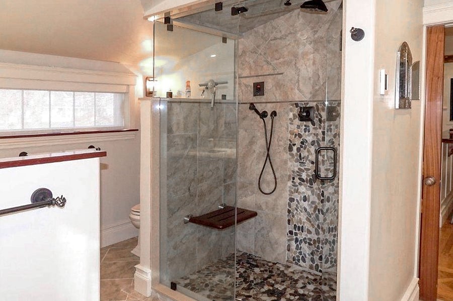 Toilet peeks out from behind the shower wall, affording a bit of privacy!