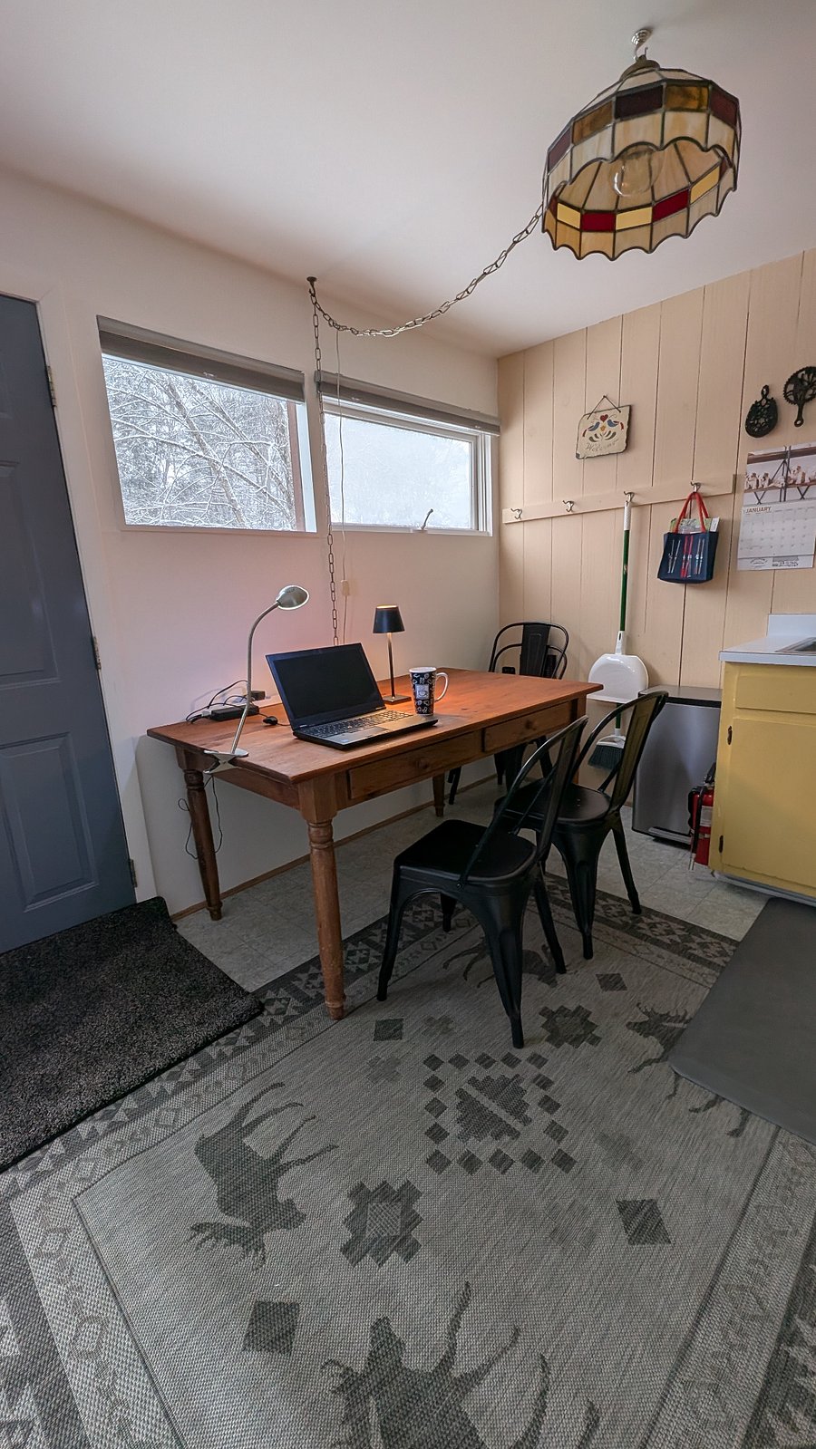 Large wooden farmhouse kitchen table with plenty of room for a workstation (laptop not included!). Surge protected power strip and plenty of lighting.