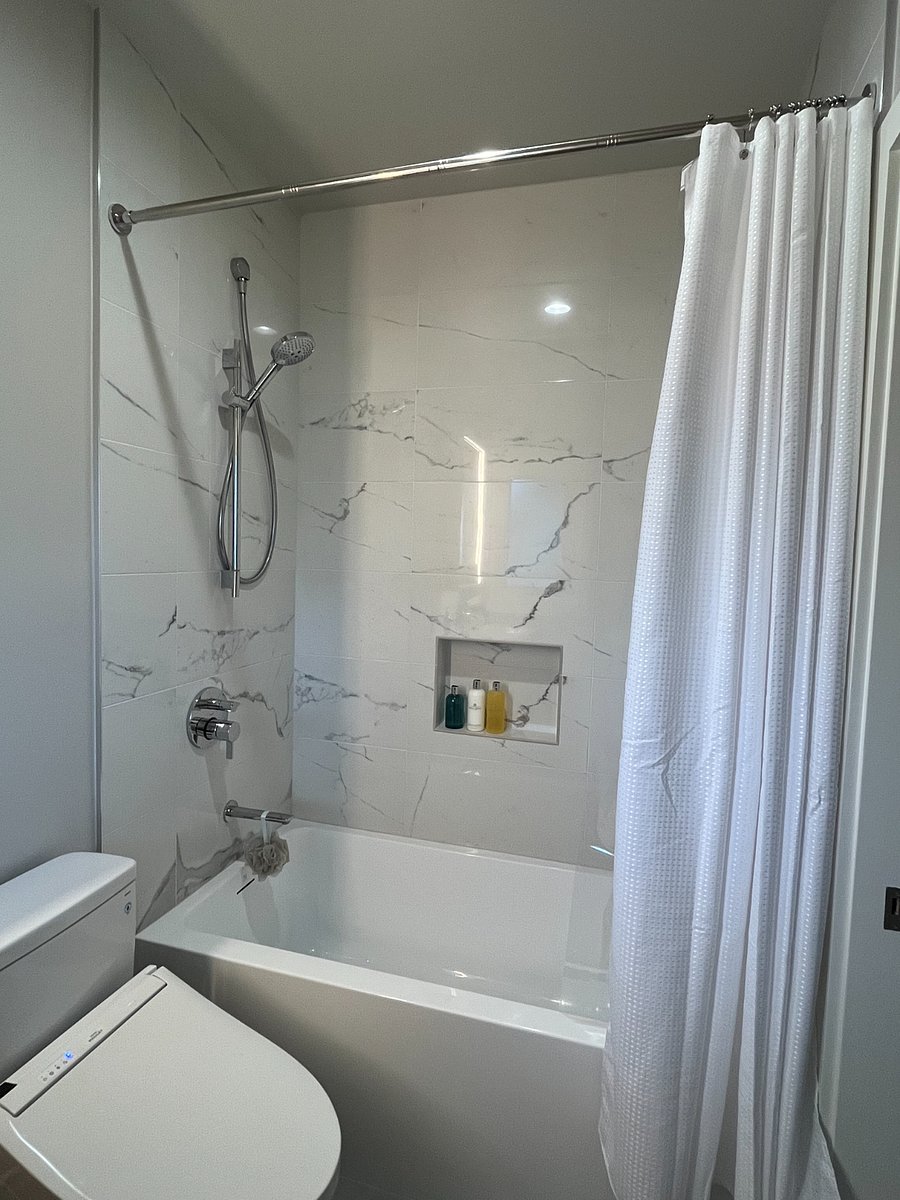 Tall bathtub with quality Hansgrohe fixtures. Calcutta polished marble finish