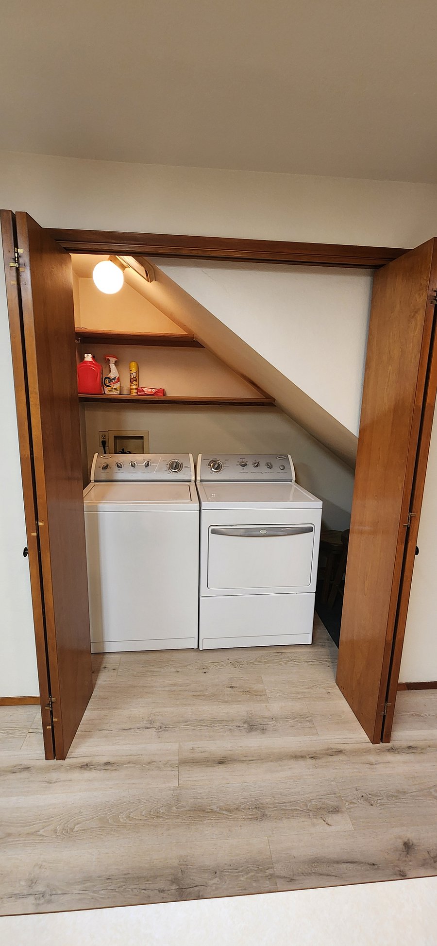 Laundry room tucked behind closet doors in the kitchen space.