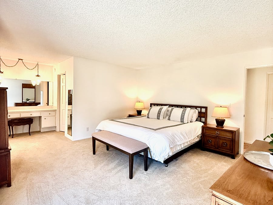Primary bedroom has two dressers and a large walk in closet.