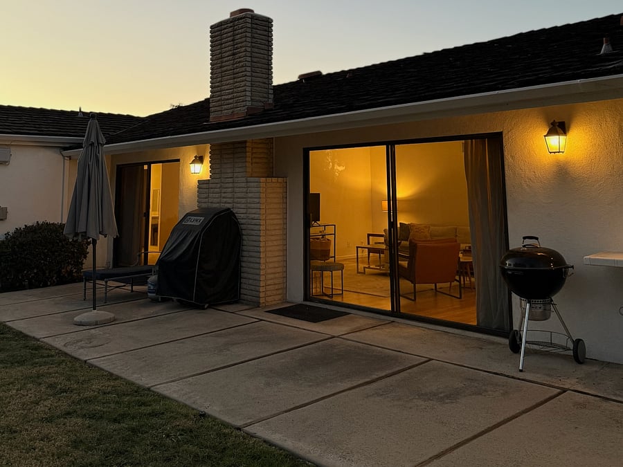 Gas grill, Weber charcoal grill and two patio umbrellas.