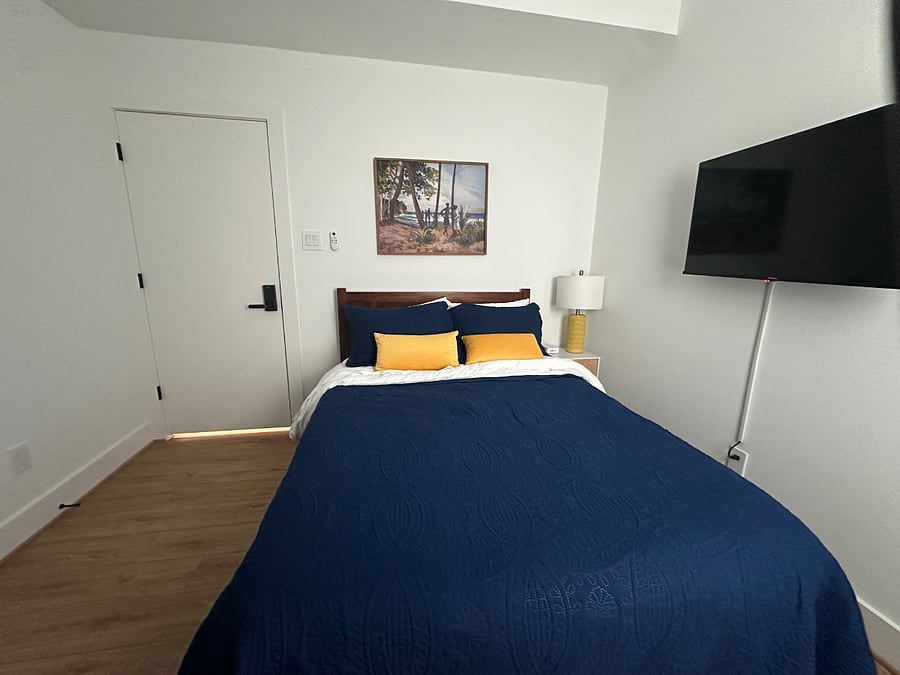 Your oasis with a cozy bed, smart TV, and foldout desk.