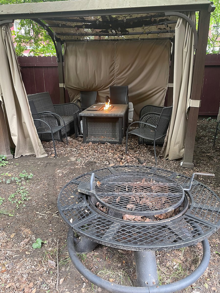 Large backyard with lighted Gazebo, multiple seating areas, fire table and plush seating 