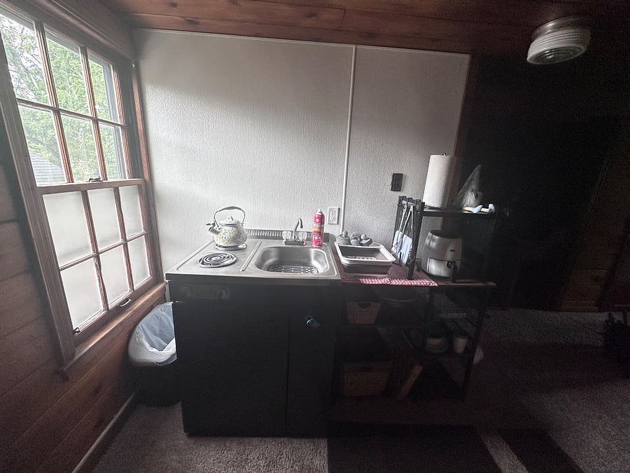 Kitchenette includes refrigerator, electric burners, and sink with hot and cold water.