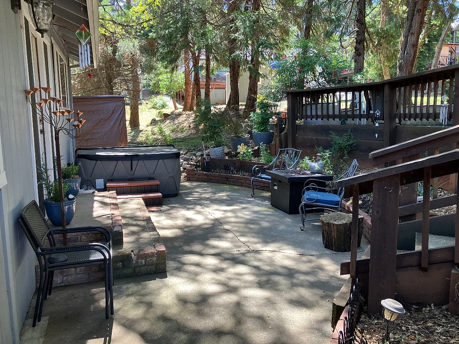 Back patio w/plug n play spa, seating stairs to huge upper patio and open space lot