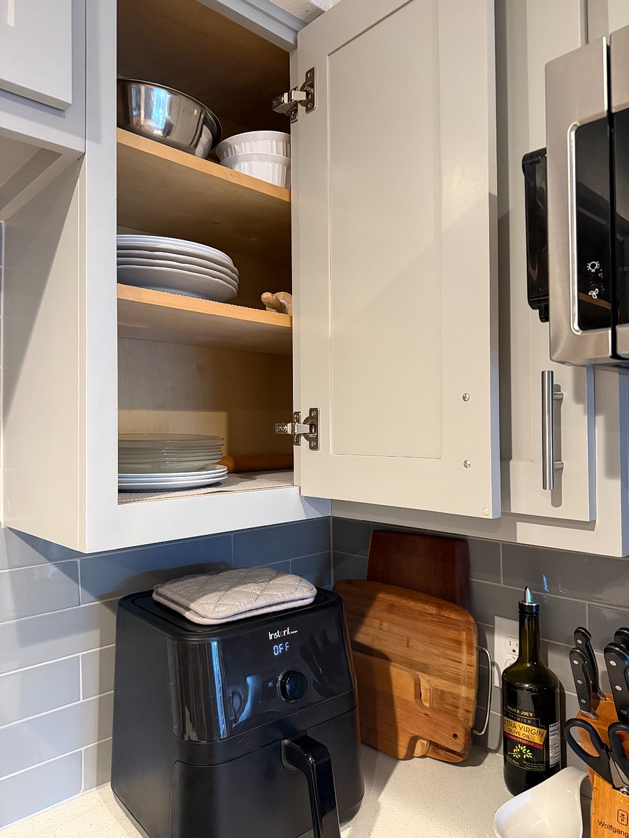 Fully stocked kitchen with plates, bowls, cups.