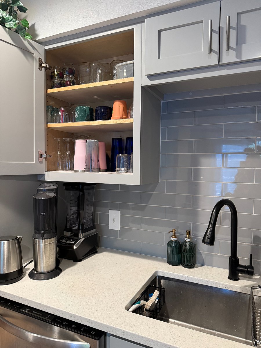 Fully stocked kitchen with plates, bowls, cups.