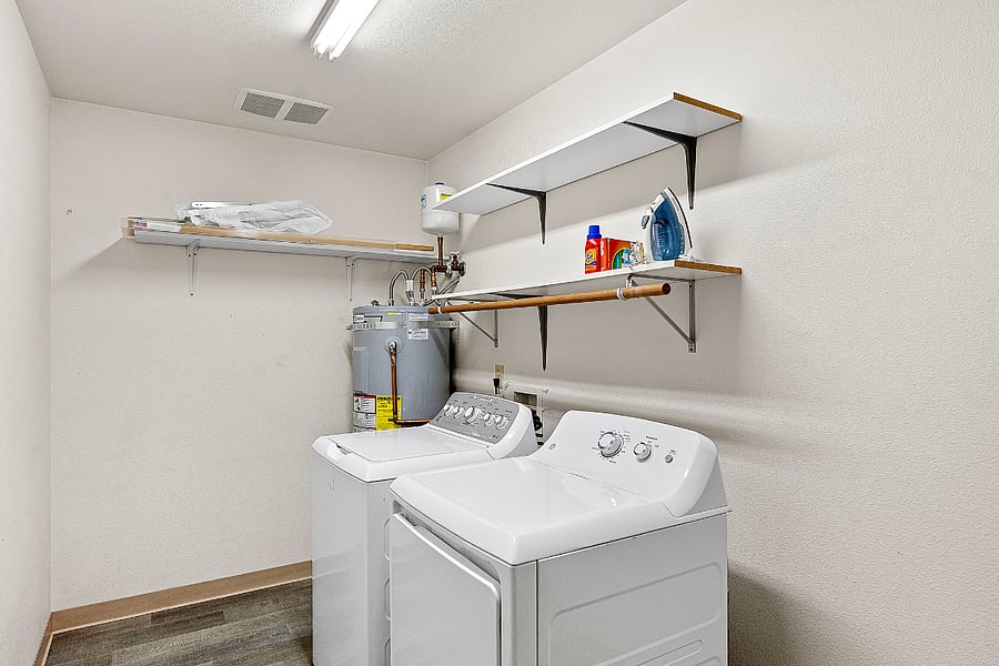 Huge walk in laundry room with iron, ironing board, drying rods