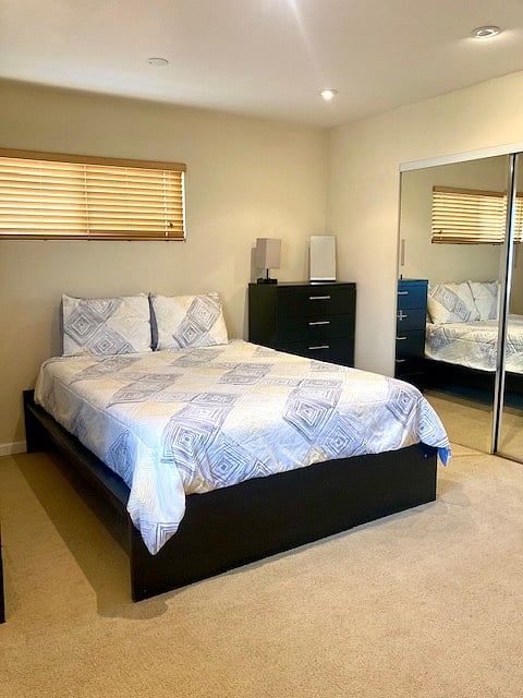 Large primary with queen bed and a couch