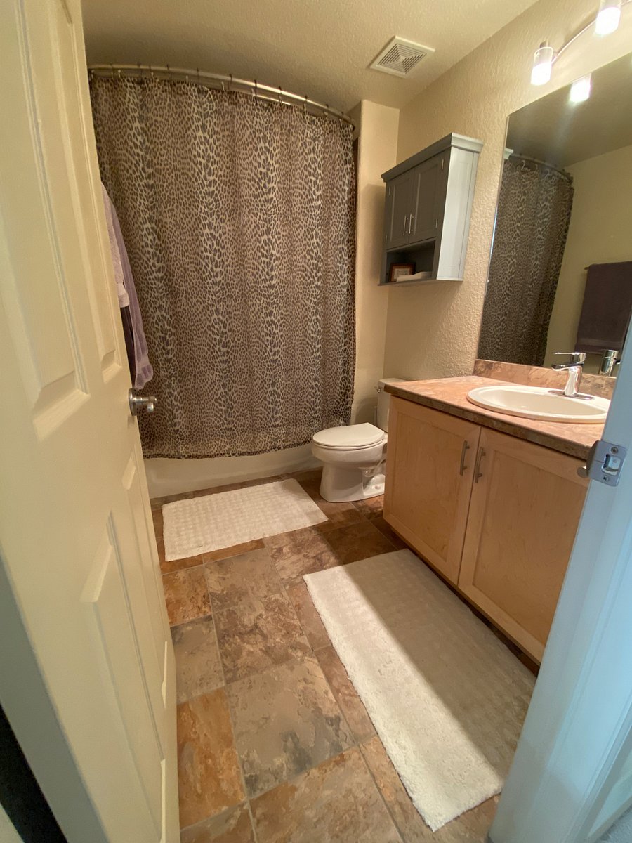Shower, bathtub, toilet and sink with storage and towel bars


