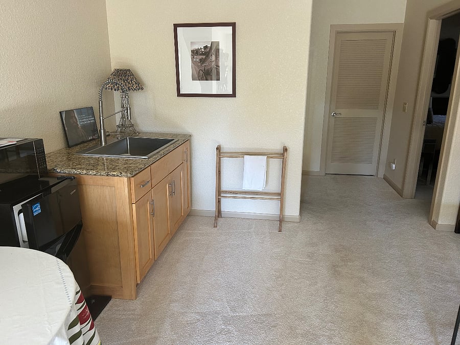 Kitchenette area with large sink, storage below, microwave and small fridge/freezer, kettle and toaster  The door to your bedroom is on the right.