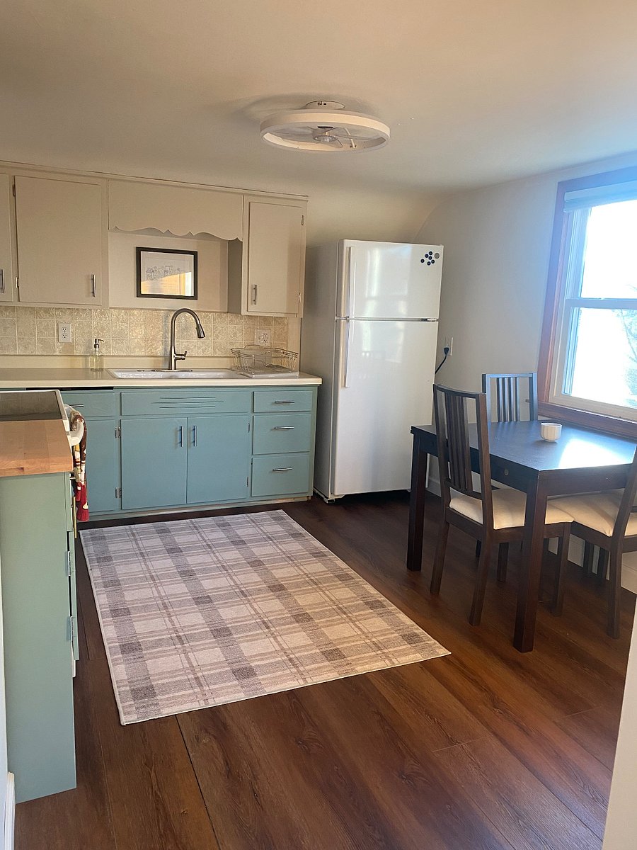Full size kitchen featuring new refrigerator, microwave vent hood, faucet, flooring and LED ceiling light with low profile fan. Fully stocked cabinets for cooking/dining at home. Full size coffee pot and Kurig.